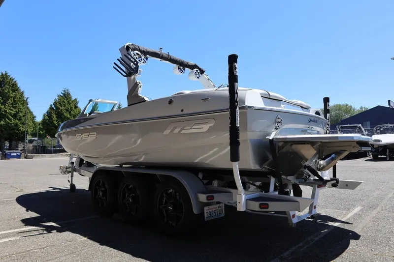 Slide: The Image of 2018 MB B52 23 boat on trailer, parked outdoors under clear blue sky. - 10