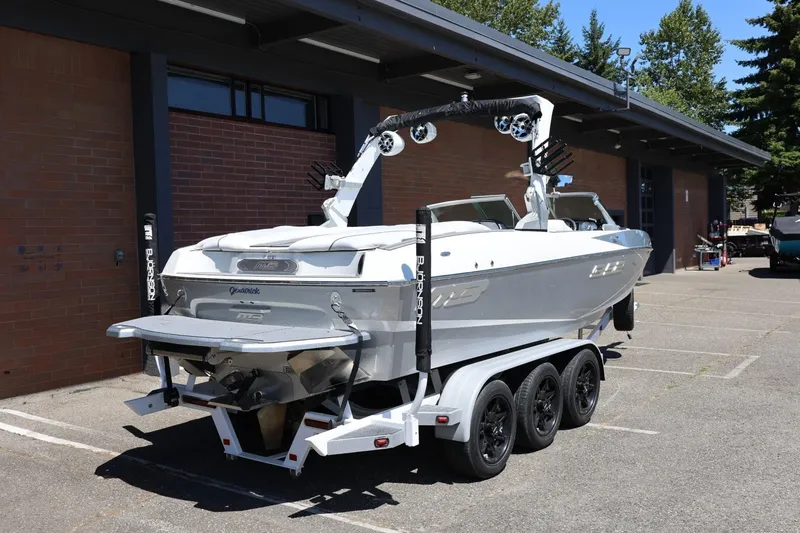 Slide: The Image of 2018 MB B52 23 boat on a trailer parked outside a brick building. - 12