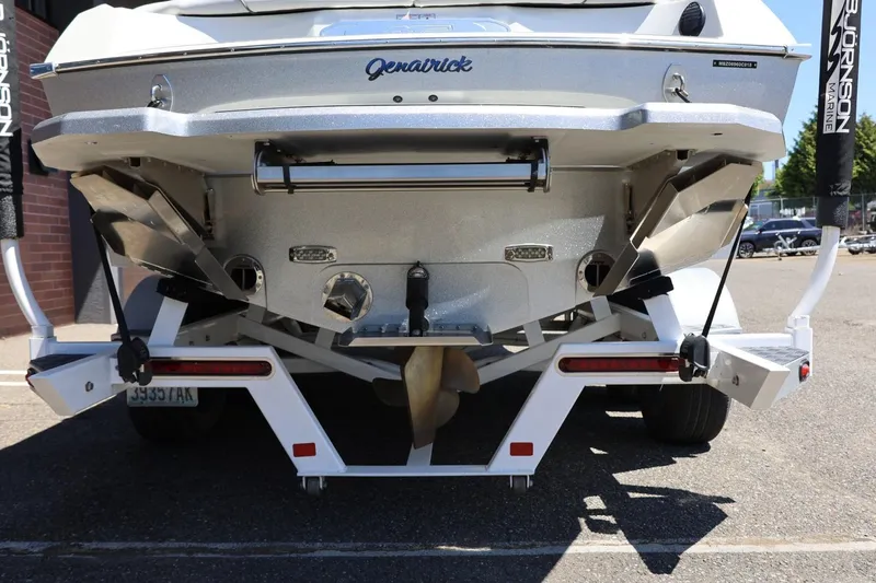 Slide: The Image of Rear view of 2018 MB B52 23 boat on trailer, showcasing propeller and trim tabs. - 13