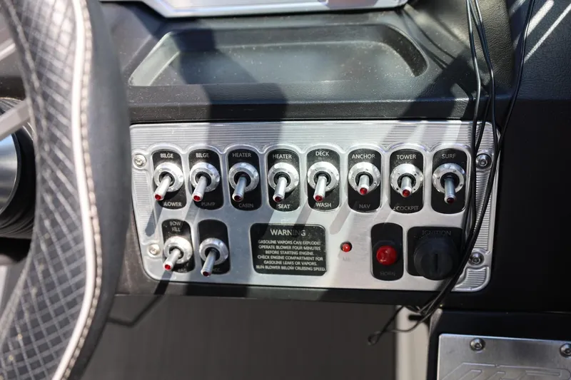 Slide: The Image of Control panel of 2018 MB B52 23 boat with various switches and warning label. - 27