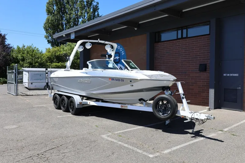 Slide: The Image of 2018 MB B52 23 boat on trailer parked outside a building. - 3