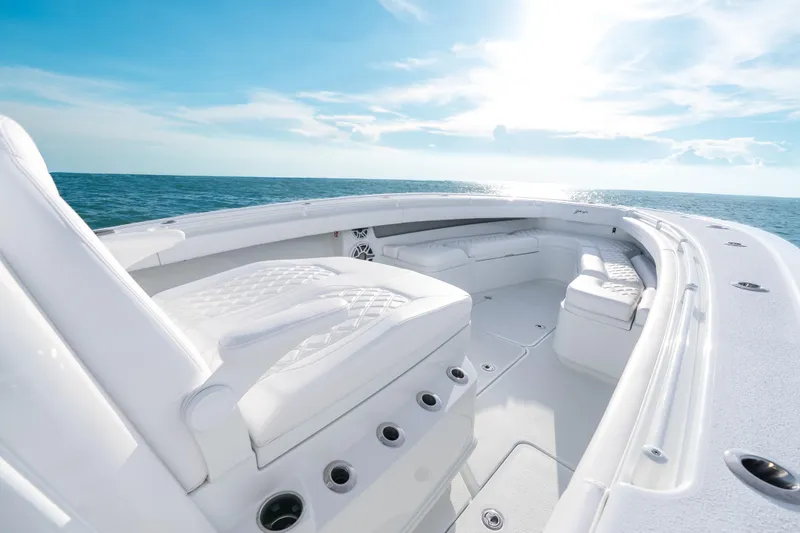 Slide: The Image of 2026 Yellowfin 36 Offshore boat interior with white seating, ocean view, and sunny sky. - 16