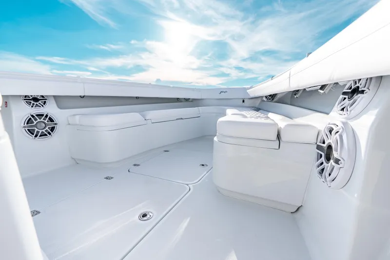 Slide: The Image of 2026 Yellowfin 36 Offshore boat interior with white seating and speakers under a blue sky. - 19