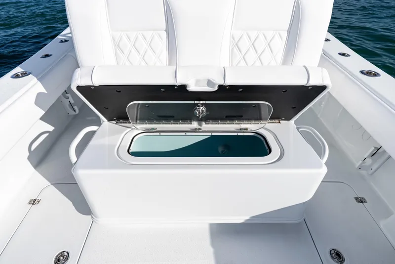 Slide: The Image of 2026 Yellowfin 36 Offshore boat with open storage compartment, white seating, and ocean backdrop. - 27