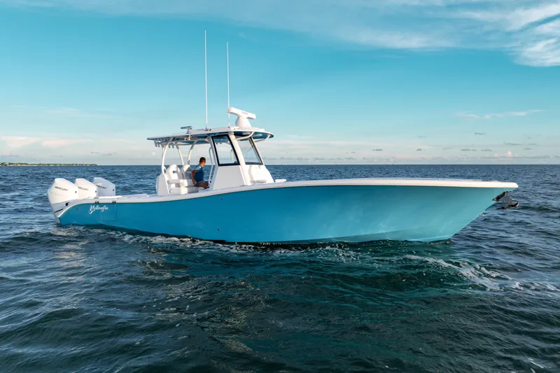 Slide: The Image of 2026 Yellowfin 36 Offshore boat cruising on open water under clear blue sky. - 9
