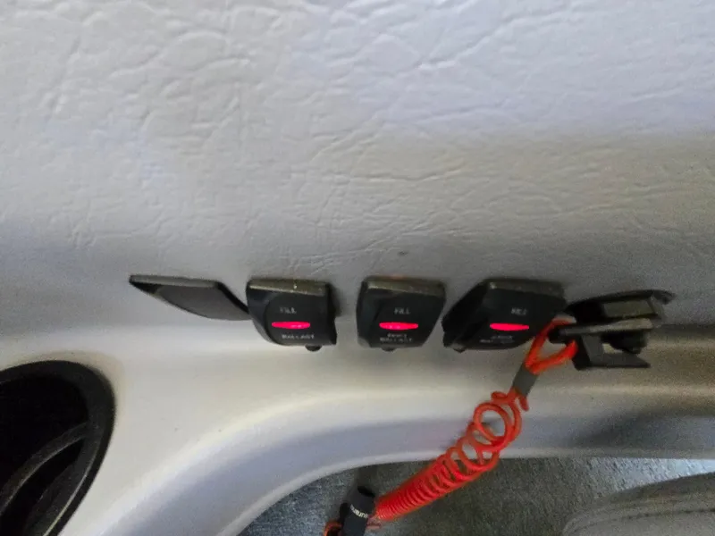 Slide: The Image of 2002 MasterCraft XStar boat control panel with switches and red coiled cord. - 11