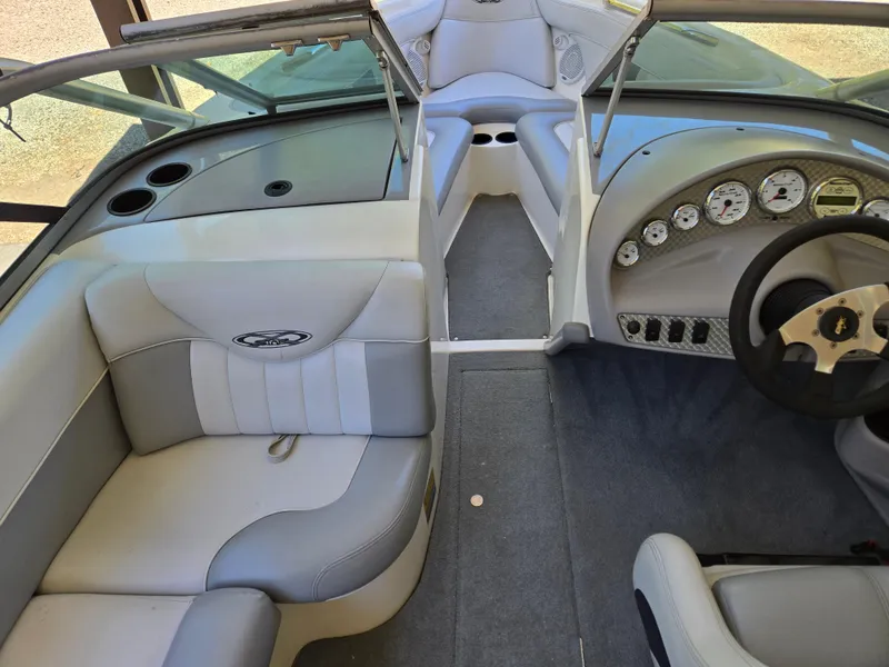 Slide: The Image of 2002 MasterCraft XStar boat interior with gray seating and dashboard controls. - 13