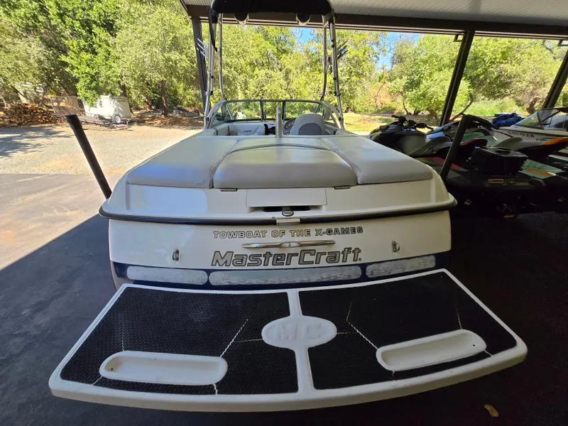 Slide: The Image of 2002 MasterCraft XStar boat with swim platform, parked under a canopy. - 9
