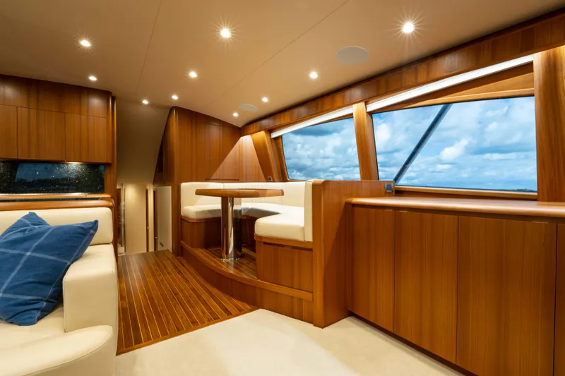 Slide: The Image of Luxurious interior of 2025 Garlington 71' Flybridge yacht with wood paneling and plush seating. - 10