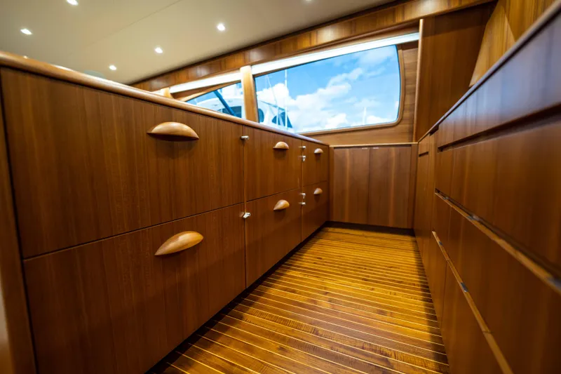 Slide: The Image of Luxurious wooden interior of 2025 Garlington 71' Flybridge yacht, featuring elegant cabinetry and flooring. - 13