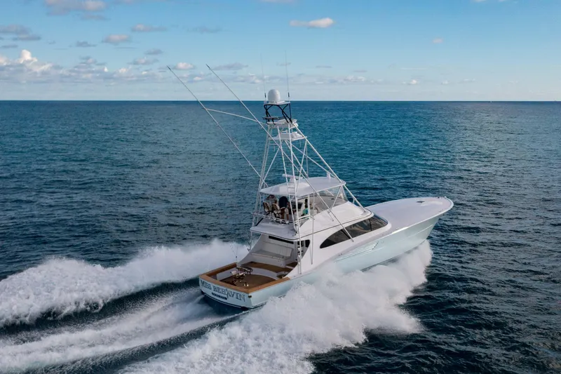 Slide: The Image of 2025 Garlington 71' Flybridge yacht cruising on open sea under clear sky. - 4