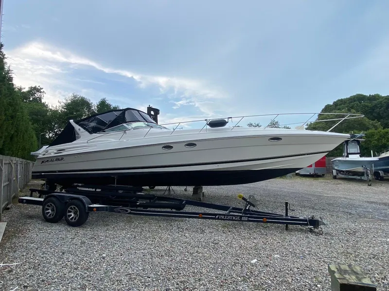 The Image of 2001 Wellcraft 45 Excalibur boat on trailer, parked outdoors on gravel. - 1