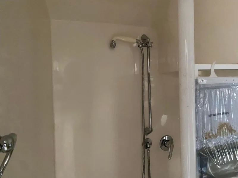 Slide: The Image of Shower area inside a 2001 Wellcraft 45 Excalibur boat, featuring a handheld showerhead. - 14