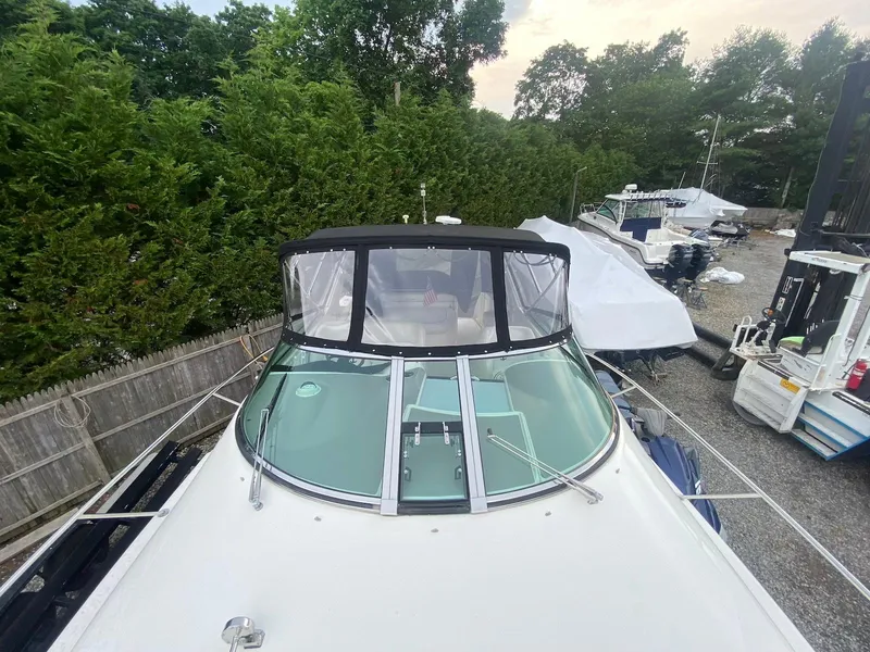 Slide: The Image of 2001 Wellcraft 45 Excalibur boat with black canopy, parked outdoors near trees. - 27