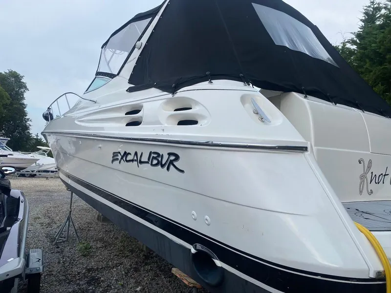 Slide: The Image of 2001 Wellcraft 45 Excalibur boat with black canopy, parked on gravel. - 28