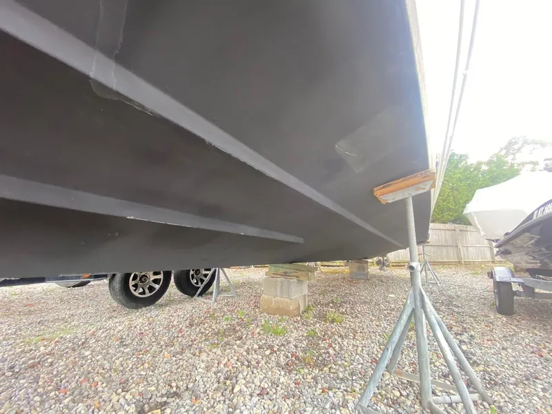 Slide: The Image of 2001 Wellcraft 45 Excalibur boat hull on stands, gravel ground, side view. - 31