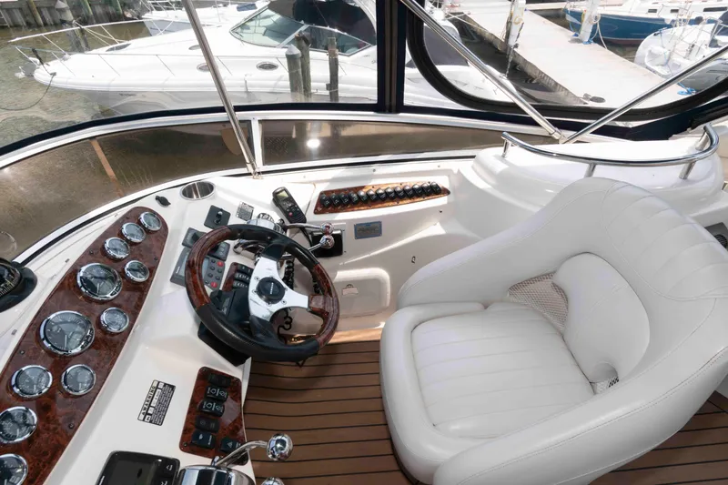 Slide: The Image of 2006 Meridian 341 Sedan helm with white leather seat and wooden dashboard. - 10