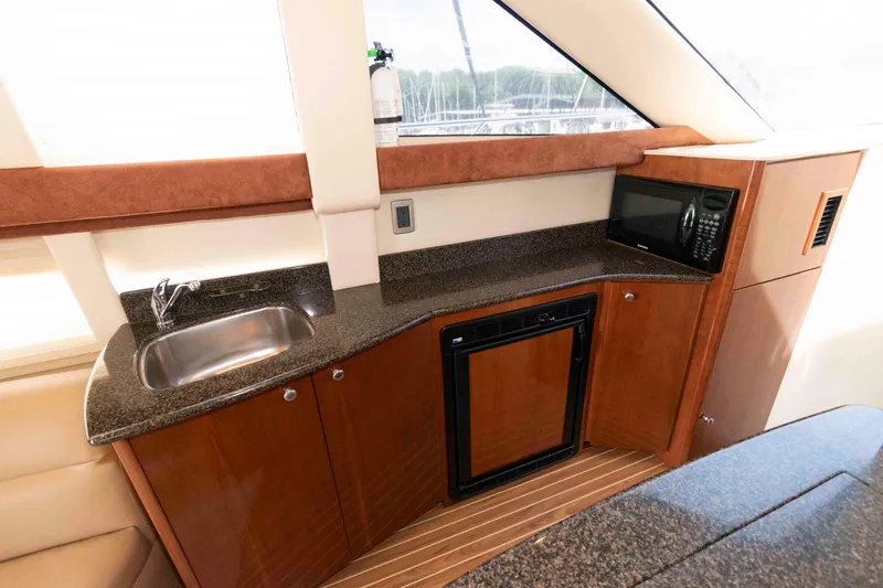 Slide: The Image of 2006 Meridian 341 Sedan yacht interior with kitchenette, featuring sink, microwave, and mini-fridge. - 18