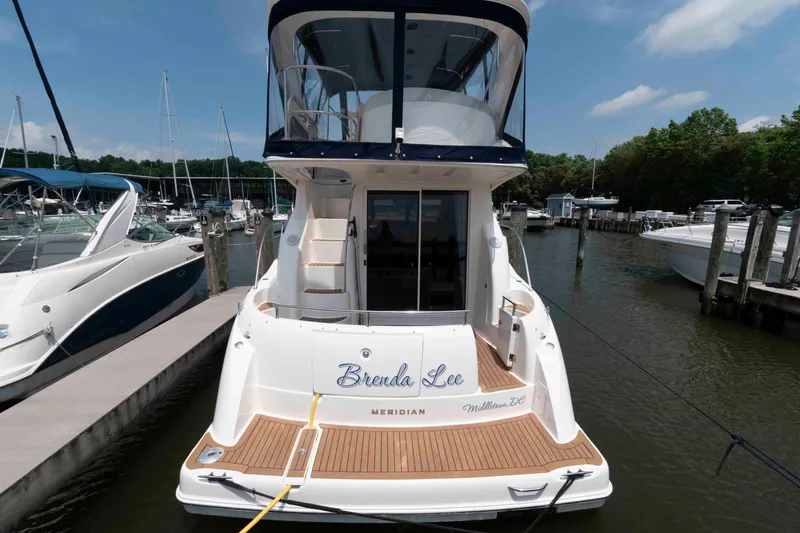 Slide: The Image of 2006 Meridian 341 Sedan yacht docked at marina, rear view with name "Brenda Lee." - 2