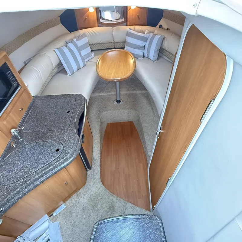 Slide: The Image of Interior of 2010 Glastron GS 289 boat with cozy seating and kitchenette. - 10