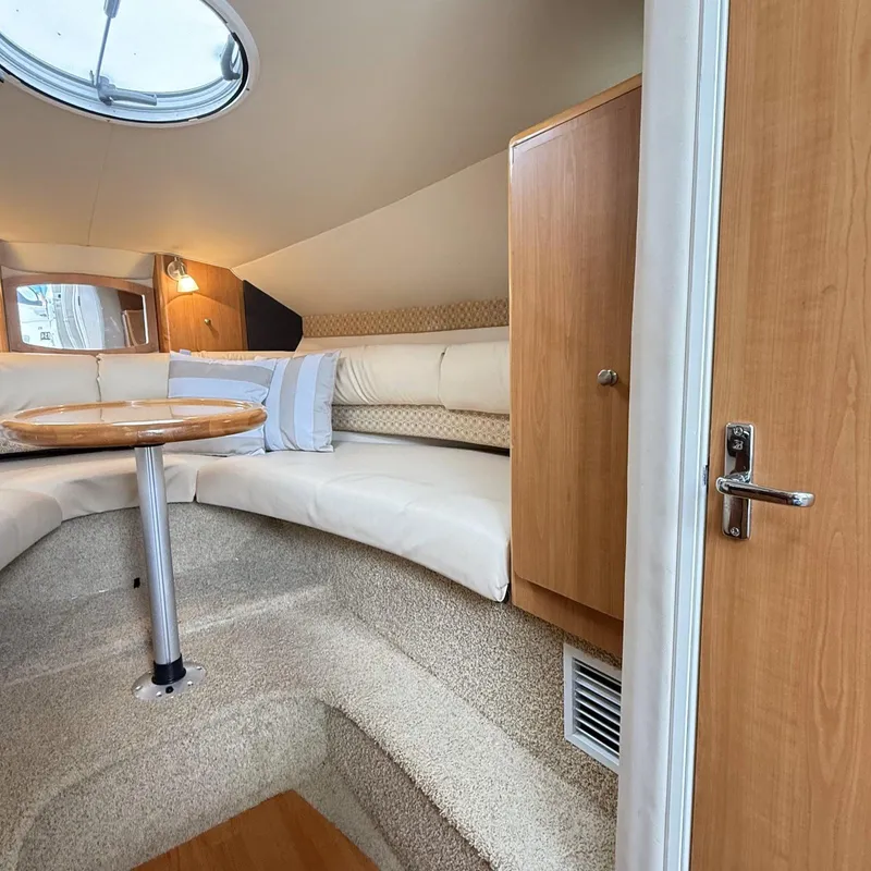Slide: The Image of Interior of 2010 Glastron GS 289 boat with cozy seating and wooden accents. - 12
