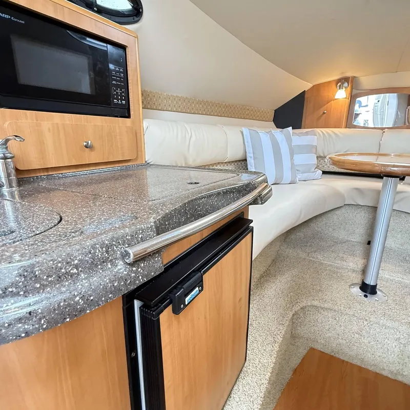 Slide: The Image of Interior of 2010 Glastron GS 289 boat with kitchenette and seating area. - 13