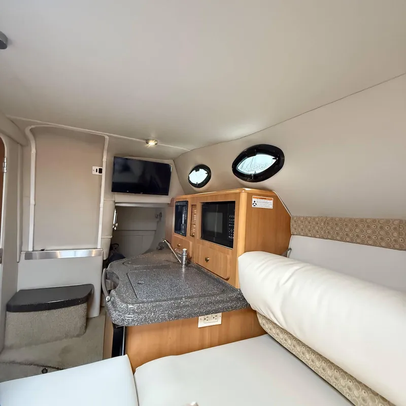 Slide: The Image of Interior of 2010 Glastron GS 289 boat with kitchenette and seating area. - 14