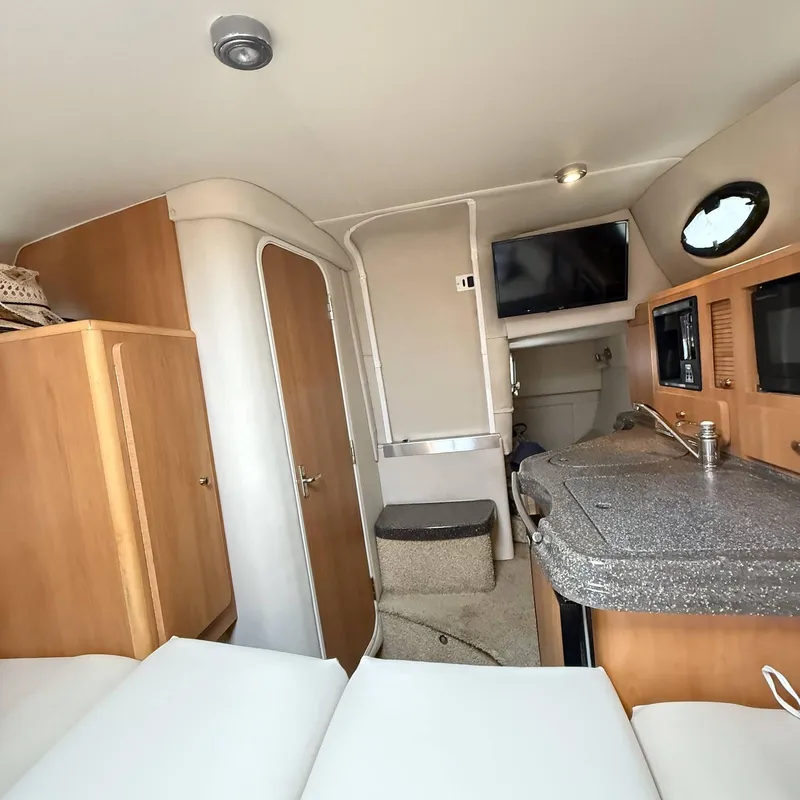 Slide: The Image of Interior of 2010 Glastron GS 289 boat with kitchenette and seating area. - 15