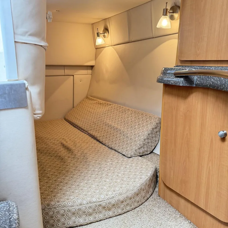 Slide: The Image of Cozy cabin interior of 2010 Glastron GS 289 boat with cushioned seating and ambient lighting. - 17