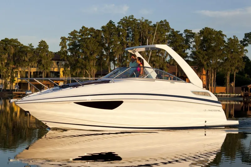 Slide: The Image of 2016 Regal 28 Express boat cruising on a calm lake. - 85