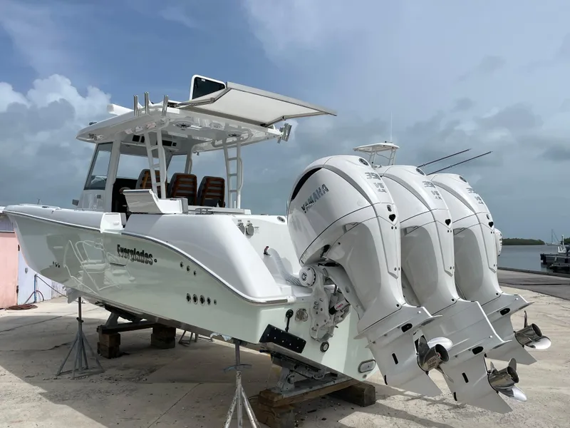 Slide: The Image of 2026 Everglades 375cc boat with triple Yamaha outboard engines on a dock. - 2