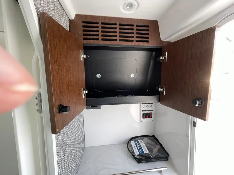 Slide: The Image of Open cabinet in 2026 Everglades 375cc boat, showing storage space and control panel. - 37