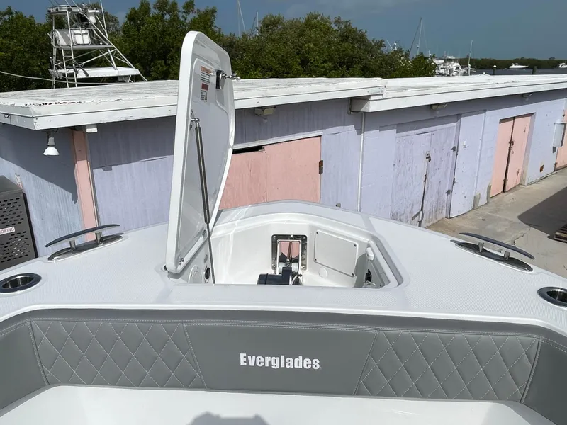 Slide: The Image of 2026 Everglades 375cc boat with open hatch, docked near pastel-colored buildings. - 8