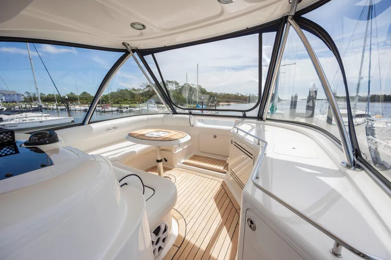 Slide: The Image of 2008 Sea Ray 58 Sedan Bridge yacht interior with seating and table, docked at marina. - 20