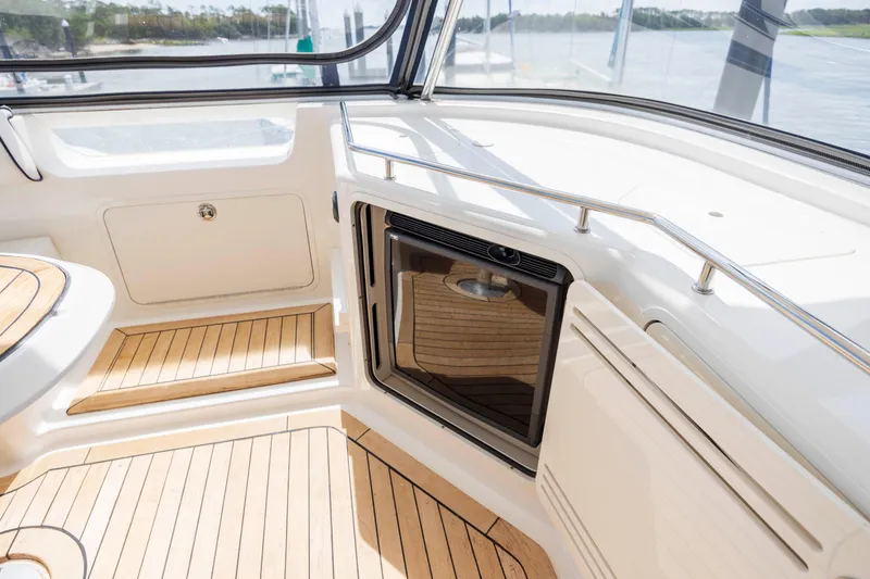 Slide: The Image of 2008 Sea Ray 58 Sedan Bridge interior with wood flooring and built-in mini fridge. - 27
