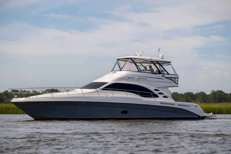 Slide: The Image of 2008 Sea Ray 58 Sedan Bridge yacht cruising on calm waters under a clear sky. - 4