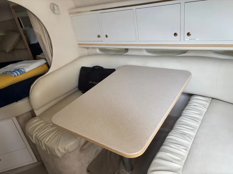 Slide: The Image of Interior of 2000 Sea Ray 310 Sundancer with dining area and storage cabinets. - 13