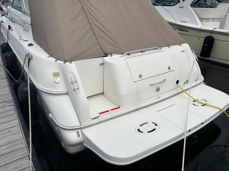 Slide: The Image of 2000 Sea Ray 310 Sundancer docked, featuring a covered stern and swim platform. - 4
