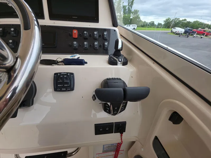 Slide: The Image of 2024 Grady-White Marlin 300 helm with controls and steering wheel, showcasing modern navigation equipment. - 10