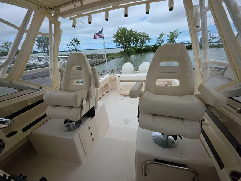 Slide: The Image of 2024 Grady-White Marlin 300 boat interior with plush seating and scenic water view. - 12