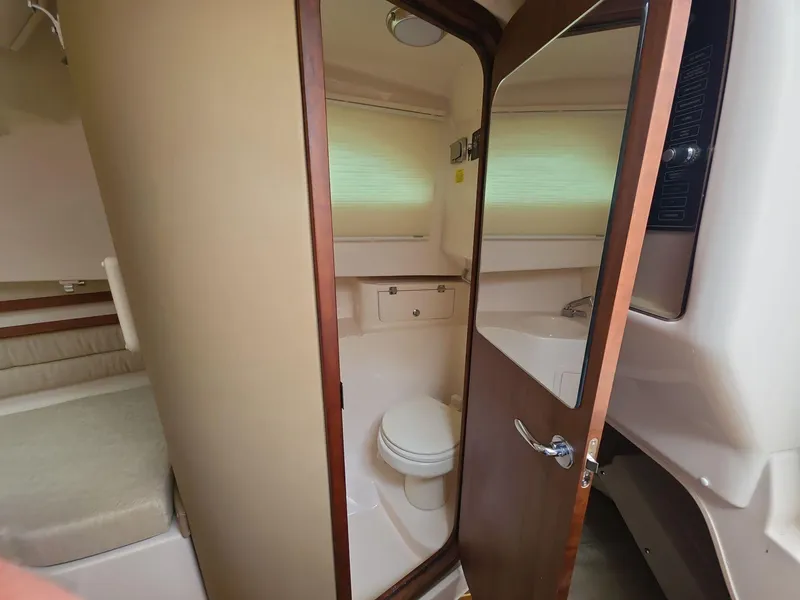 Slide: The Image of 2024 Grady-White Marlin 300 cabin interior with bathroom and bed. - 13