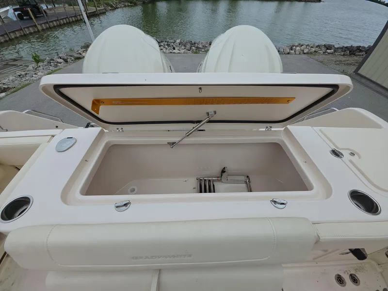 Slide: The Image of 2024 Grady-White Marlin 300 boat with open storage compartment by the water. - 17