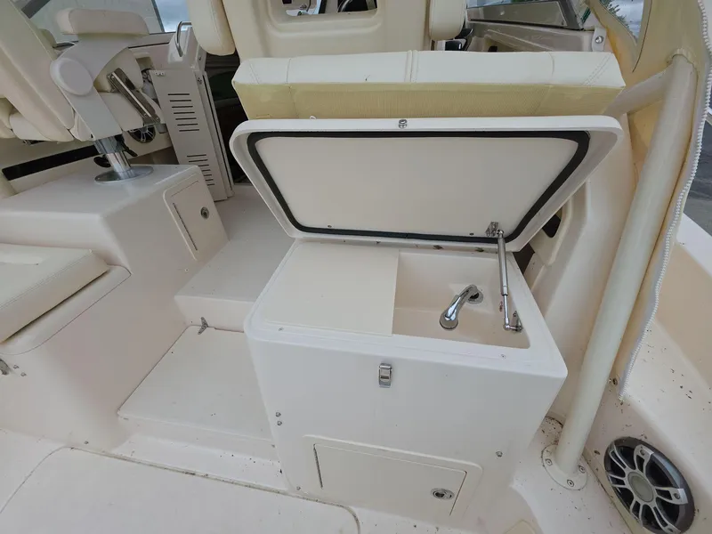 Slide: The Image of 2024 Grady-White Marlin 300 boat interior with open storage compartment and sink. - 18