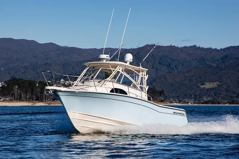 Slide: The Image of Manufacturer Provided Image: 2024 Grady-White Marlin 300 boat cruising on a lake with mountains in the background. - 24