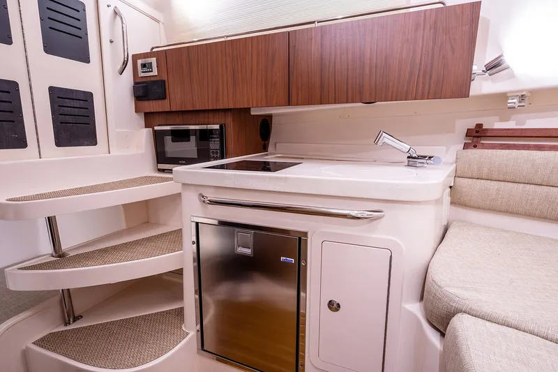 Slide: The Image of Manufacturer Provided Image: 2024 Grady-White Marlin 300 boat interior with kitchenette, microwave, and stairs. - 33