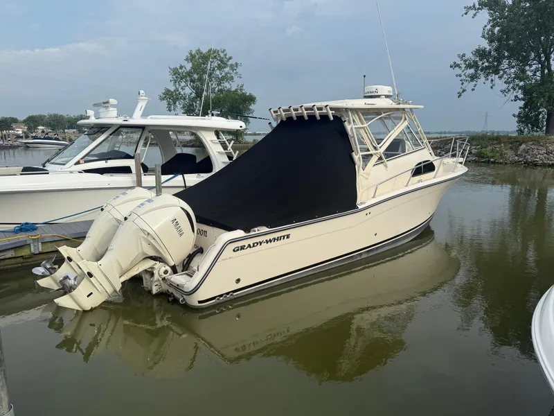 Slide: The Image of 2024 Grady-White Marlin 300 boat docked with Yamaha engines, covered in black tarp. - 5