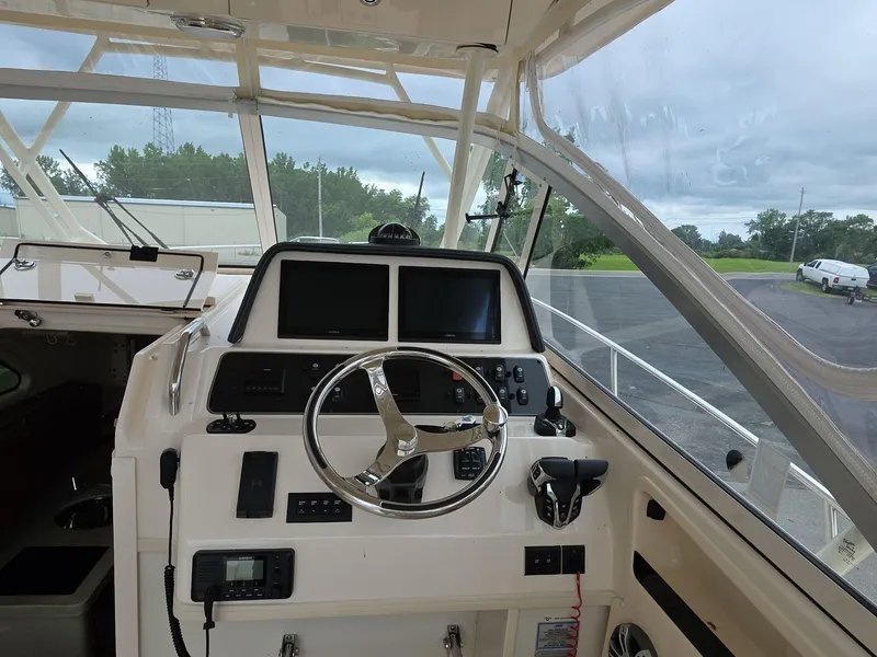 Slide: The Image of 2024 Grady-White Marlin 300 helm with dual screens and steering wheel. - 9