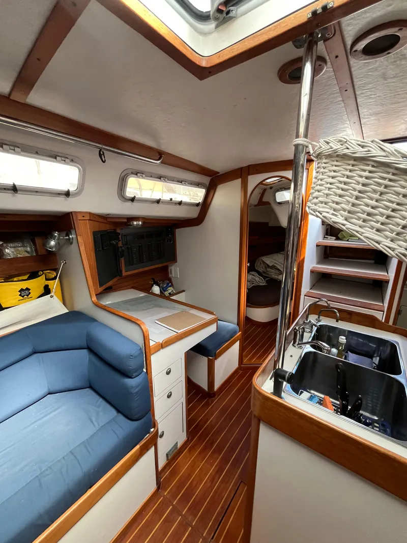Slide: The Image of Interior of 1994 J Boats J 40 sailboat with cozy seating, wooden flooring, and compact kitchen. - 21