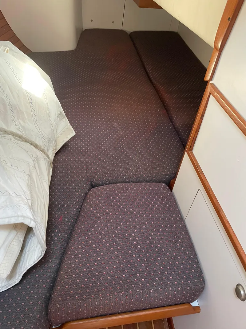 Slide: The Image of Interior cabin of 1994 J Boats J 40, featuring a cozy bed with patterned upholstery. - 33