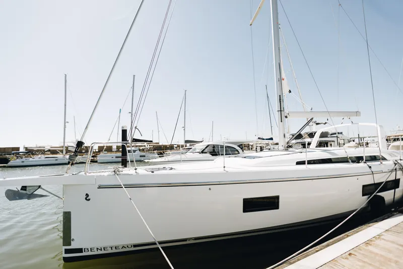 Slide: The Image of 2024 Beneteau Oceanis 51.1 yacht docked in a marina under clear skies. - 0